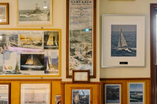a wall with framed pictures of boats and ships at Shipwrights Arms Hotel in Hobart