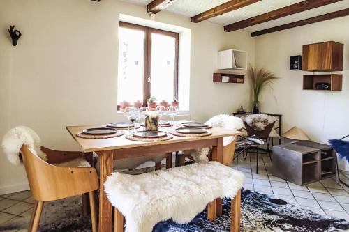 uma sala de jantar com uma mesa de madeira e cadeiras em Maison de ville de 100m2 proche centre-ville/lac em Annecy