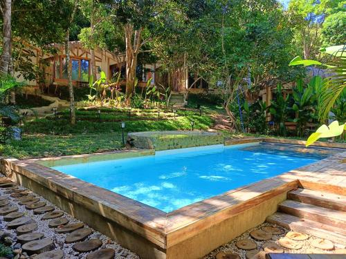 a large swimming pool with a wooden deck around it at Kawai Duli Bungalows in El Nido