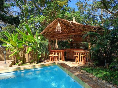 a resort with a swimming pool and a wooden hut at Kawai Duli Bungalows in El Nido