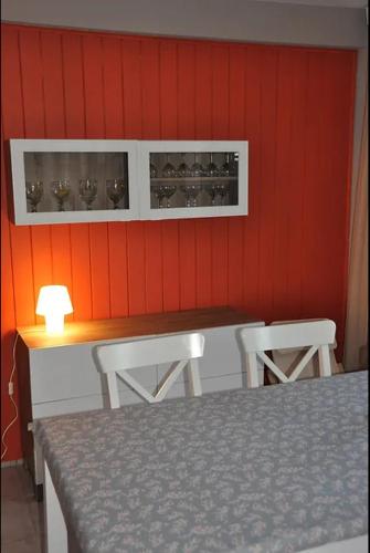 une cuisine avec des murs rouges et une table et des chaises dans l'établissement 260 lake waterfront holiday apartment with garden, à Hourtin