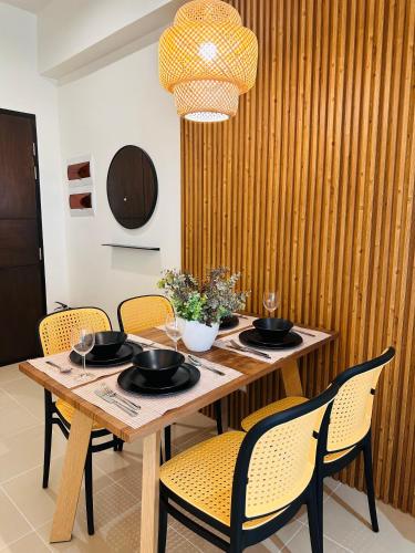 a dining room table with chairs and a chandelier at Studio K- Japandi-Inspired Condo Unit at The Palladium in Iloilo City