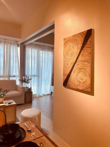 a living room with a painting hanging on the wall at Studio K- Japandi-Inspired Condo Unit at The Palladium in Iloilo City