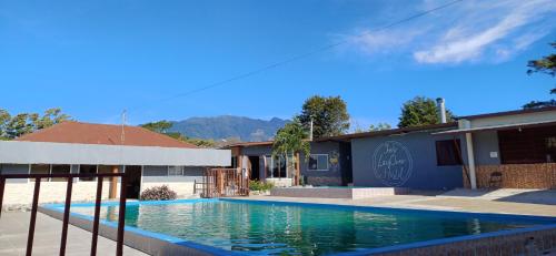 a swimming pool in front of a building at Joe's Layover Hostel Boquete in Boquete