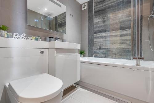 y baño blanco con aseo y ducha. en Elegant Living in Kingston: Two Bedroom Apartment, en Kingston upon Thames