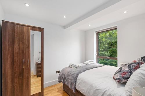 um quarto com uma cama grande e uma janela em Elegant Living in Kingston: Two Bedroom Apartment em Kingston upon Thames