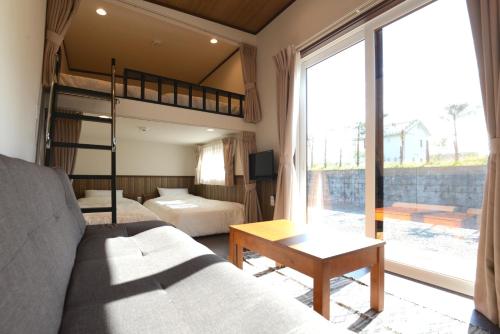 um quarto com um beliche e um sofá em Mt Fuji Glamping VILLA Kawaguchiko em Fujikawaguchiko