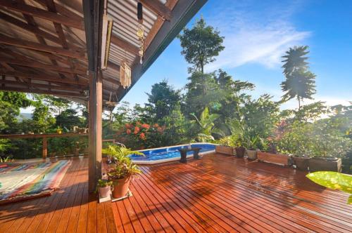una terraza al aire libre con piscina y árboles en Magic Mena Rainforest Retreat en Mena Creek