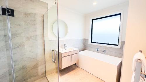 une salle de bain avec un lavabo et une douche en verre dans l'établissement Brand New House with 5 bedroom and 3 full bathroom, à Rotorua