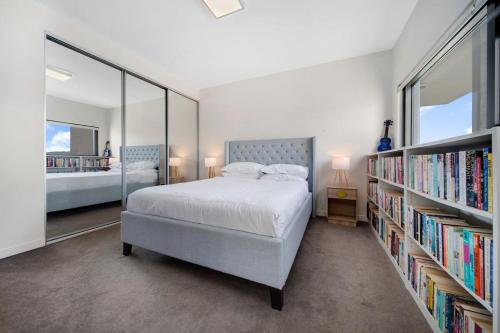 a bedroom with a bed and book shelves with books at Cosy 1-Bed With Balcony Pool & Leisure Area in Lyons