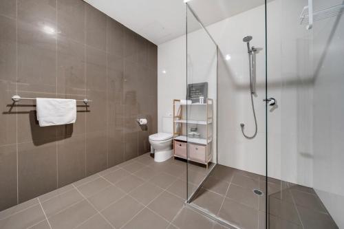 a bathroom with a toilet and a glass shower at Cosy 1-Bed With Balcony Pool & Leisure Area in Lyons