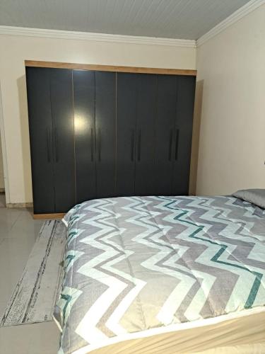 1 dormitorio con 1 cama con armarios negros en Casa Criciúma, en Criciúma