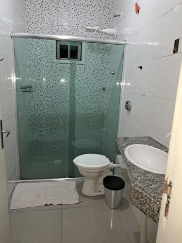 a bathroom with a shower and a toilet and a sink at Casa Criciúma in Criciúma