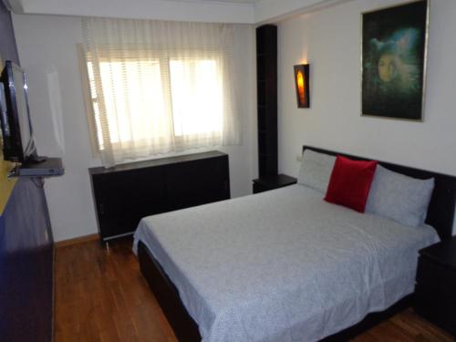 1 dormitorio con cama blanca y almohada roja en Casablanca en Casablanca