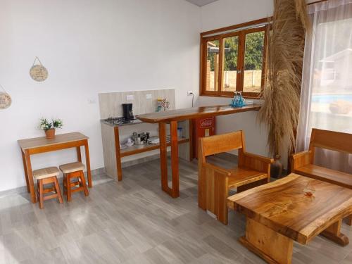 a kitchen with wooden tables and chairs and a counter at Eco Cabañas Montana in Santa Helena