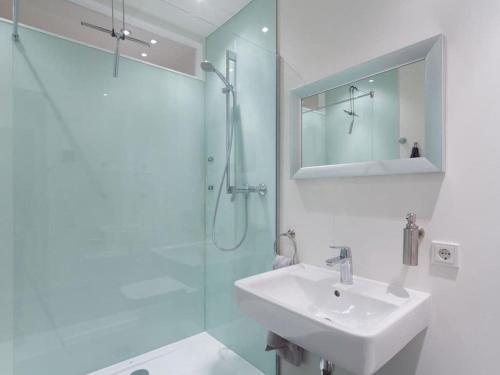 a white bathroom with a sink and a shower at Apartment in Lübeck-Travemünde in Rönnau