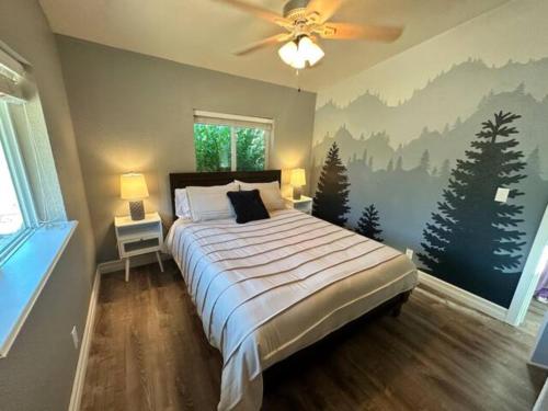 Schlafzimmer mit einem Bett und einem Deckenventilator in der Unterkunft Enchanting Getaway Farmhouse And Tiny House Duo in Jacksonville