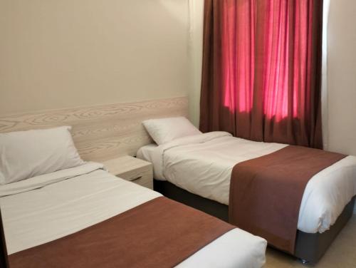 a room with two beds and a red curtain at Nozha Beach - Ras Sudr in Ras Sedr