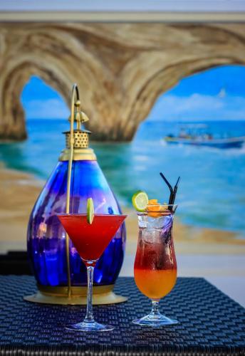 two cocktails on a table next to a blue vase at Lagoa Hotel in Lagoa