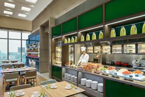 a chef standing behind a counter in a restaurant at Courtyard by Marriott Singapore Novena in Singapore