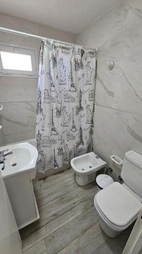 een badkamer met een wastafel, een toilet en een douchegordijn bij Complejo Chile Plottier in Plottier