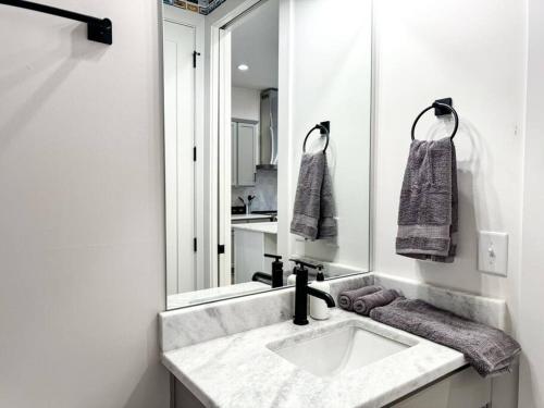 ein Badezimmer mit einem Waschbecken und einem großen Spiegel in der Unterkunft 4BR 4BA City Gem ROOFTOP Sleeps 12 in Nashville
