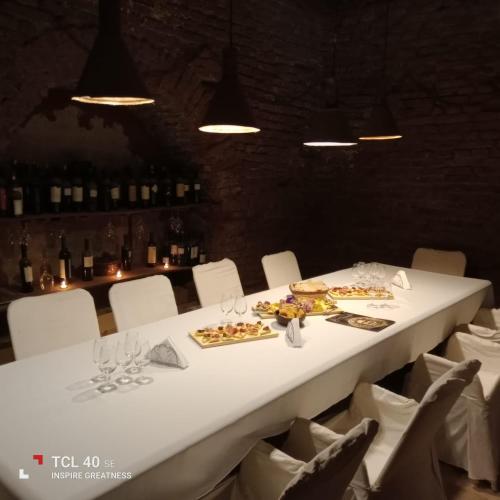 a long white table with white chairs and food on it at el oráculo. cava de vinos. unión club in El Sauce