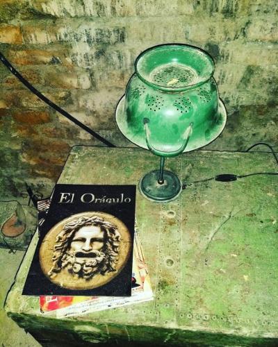 a green glass sitting on a table next to a book at el oráculo. cava de vinos. unión club in El Sauce