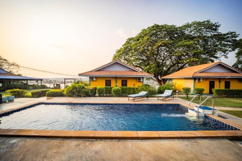 a swimming pool in front of a house at Khong Chiam Orchid Riverside Resort in Khong Chiam