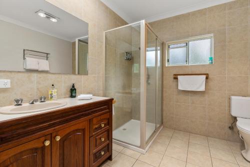 uma casa de banho com um chuveiro, um lavatório e um WC. em Bon Villas B&B Bonville em Coffs Harbour