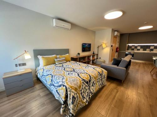 a bedroom with a bed and a couch and a chair at RIACENTRUM - Smart Residence in Aveiro