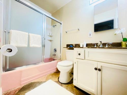 uma casa de banho com um chuveiro, um WC e um lavatório. em GREAT FOR BUSINESS & FAMILY TRIPS 3BD 2BA close to DESNEYLAND, FREE PARKING em Orange