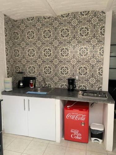 a kitchen with a cocacola refrigerator and a counter at Alojamiento en Tlaquepaque Céntro in Guadalajara