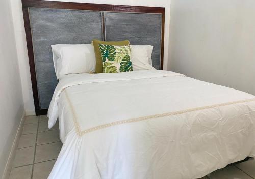 a large white bed with two pillows on it at Bahiamar in Pampatar