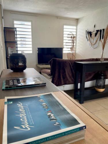 a book sitting on a table in a living room at Appartement cosy en ville in Baie-Mahault