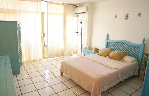 a bedroom with a blue bed with yellow pillows on it at Hermoso Departamento Frente Al Mar & Sobre Costera in Acapulco