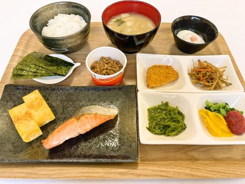 a table with plates of food and bowls of food at Hotel Alpha-One Miyoshi in Miyoshi