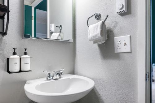a white bathroom with a sink and a mirror at Oxford Apartment by At Mine Hospitality in Seattle