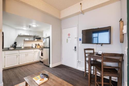 a kitchen with a table and a television on a wall at Oxford Apartment by At Mine Hospitality in Seattle
