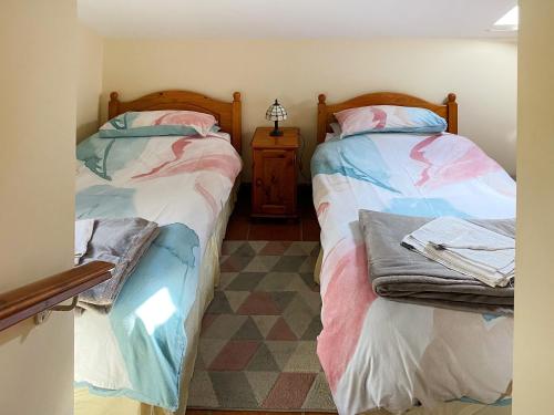 two beds sitting next to each other in a room at Bramble Cottage-19878 in Cloughton