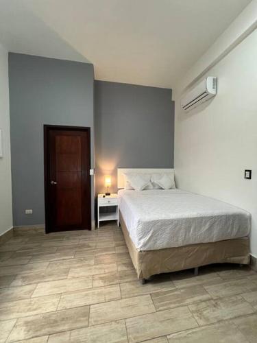 a bedroom with a bed and a table and a door at Casa G&V x 8 personas in Flores