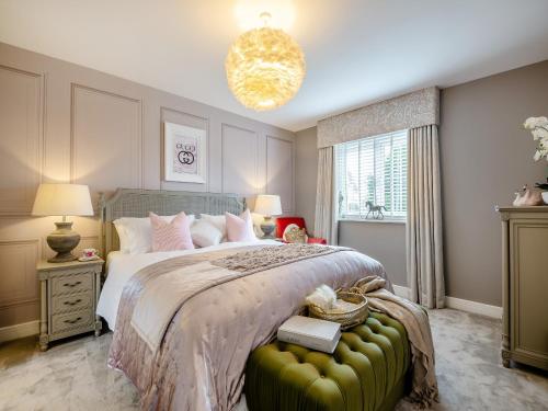 um quarto com uma cama grande e um repousa-pés verde em Dukes House em Corsham