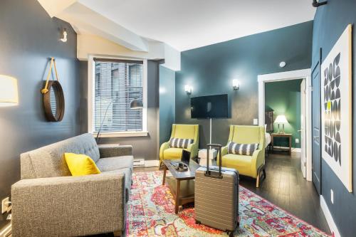 a living room with two chairs and a suitcase at Oxford Apartment by At Mine Hospitality in Seattle