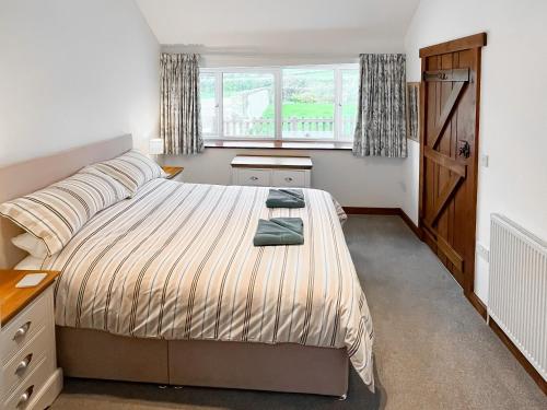 een slaapkamer met een bed en een raam bij Woodpecker in Burton Bradstock