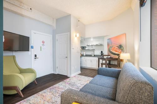 a living room with a blue couch and a kitchen at Oxford Apartment by At Mine Hospitality in Seattle
