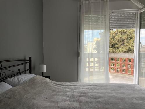 a bedroom with a bed and a large window at Luxurious 3rd floor apartment with elevator in Alexandroupoli