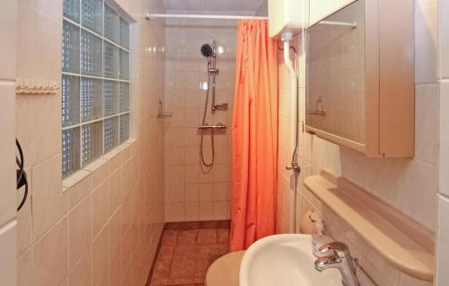 baño con cortina de ducha naranja y lavamanos en Awesome Home In Liepgarten With Kitchen, en Liepgarten