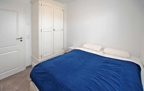 a white room with a bed with blue sheets at Nice Apartment In Userin Ot Gro Quassow With Wifi in Groß Quassow