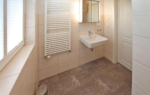 a white bathroom with a sink and a mirror at Nice Apartment In Userin Ot Gro Quassow With Wifi in Groß Quassow