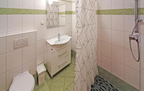 een badkamer met een toilet, een wastafel en een douche bij 4 Bedroom Amazing Apartment In Kuchelmi in Kuchelmiß